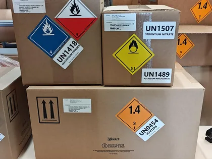 Dangerous goods packaging - cartons labelled with UN1418, UN1507, UN1489 and UN0454 hazard class labels