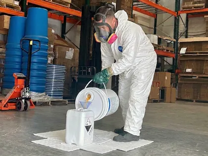 Palletization and strapping - warehouse operator strapping a shrink-wrapped and overpacked pallet of dangerous goods for transport